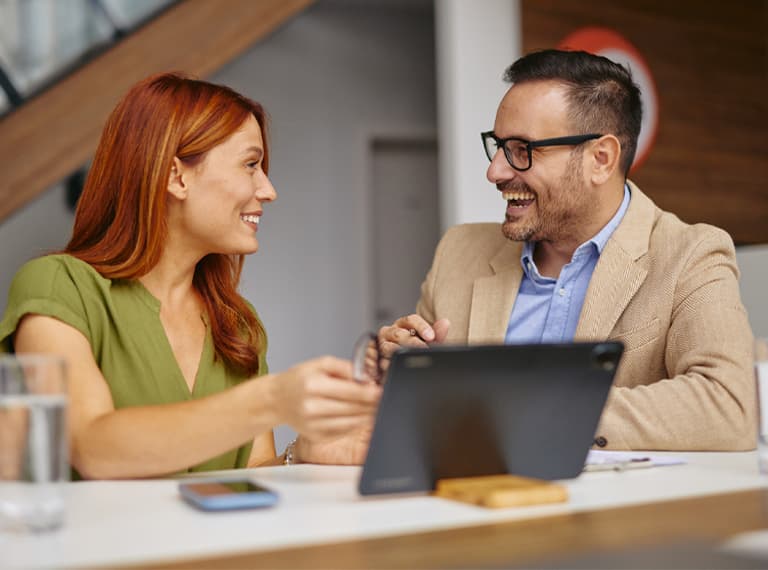 A diverse group of professionals in an office setting, engaging in a friendly meeting. The atmosphere is collaborative, promoting teamwork and positive communication among colleagues.