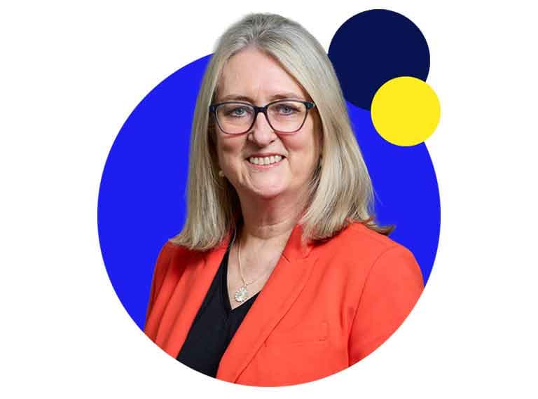 Woman with blonde hair and glasses wearing an orange blazer, smiling against a blue circular background with yellow accent.