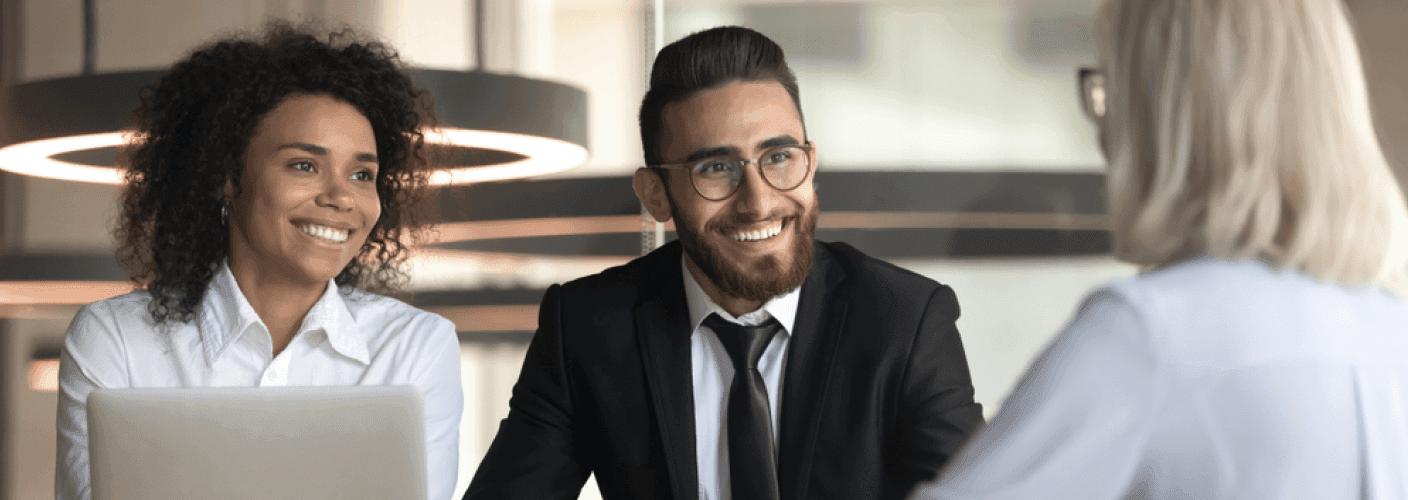 2 people in office attire smiling at a 3rd person