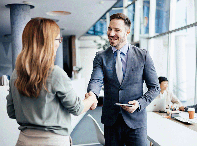 Man dressed in suit shaking hands with colleague