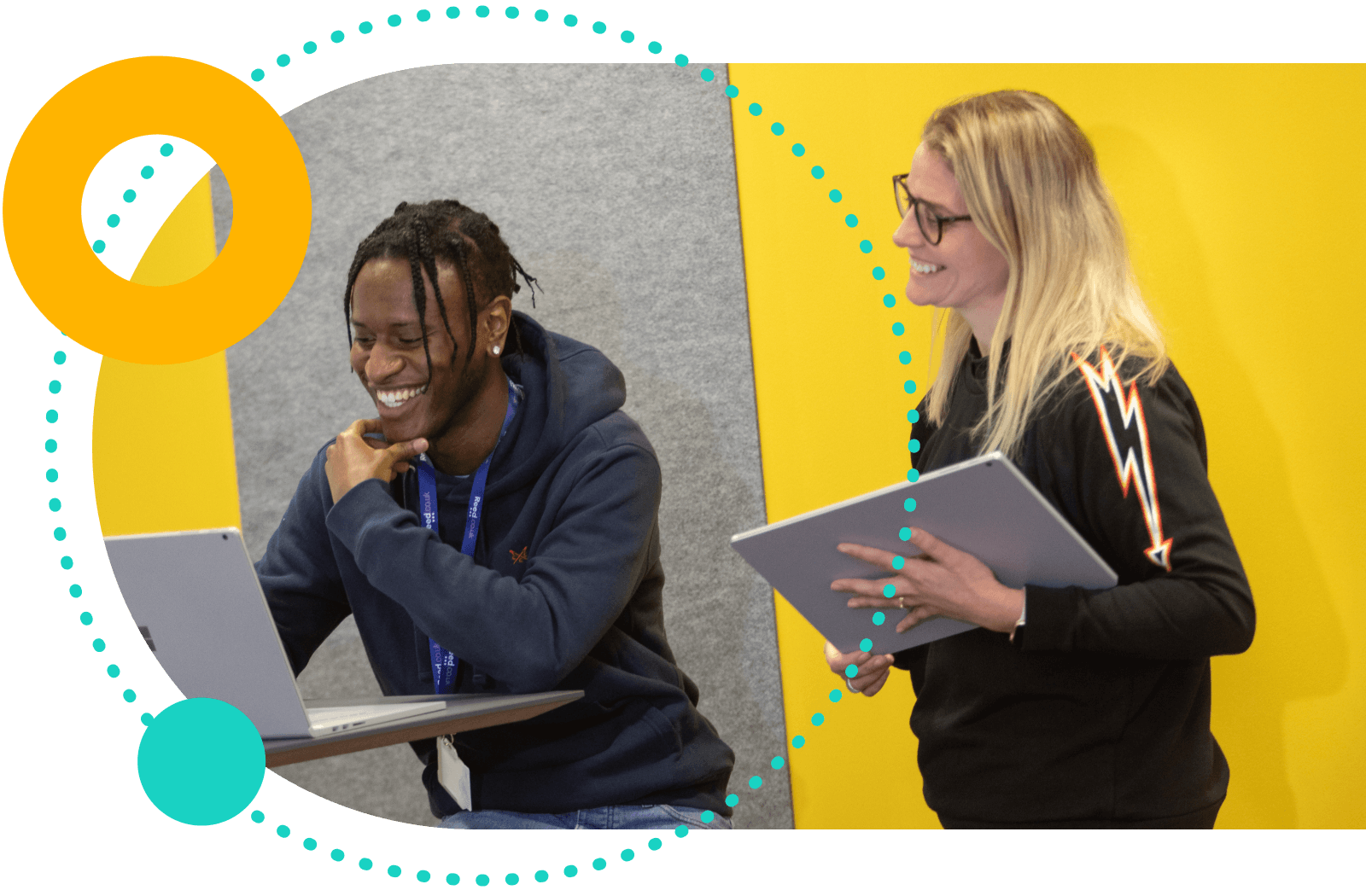 People smiling and looking at a laptop